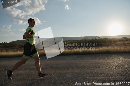 Image of triathlon athlete running on morning trainig