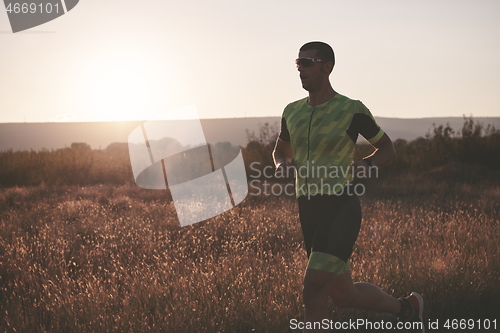 Image of triathlon athlete running on morning trainig