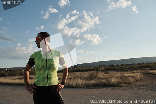 Image of triathlon athlete resting and setting smartwatch