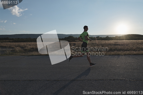 Image of triathlon athlete running on morning trainig