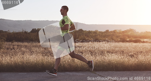 Image of triathlon athlete running on morning trainig