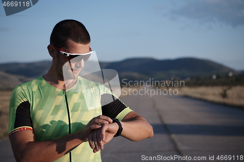 Image of triathlon athlete resting and setting smartwatch