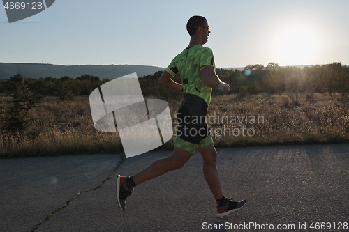 Image of triathlon athlete running on morning trainig