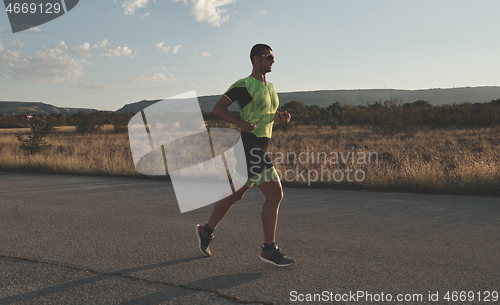 Image of triathlon athlete running on morning trainig