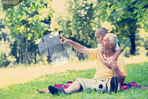 Image of grandfather and child have fun  in park