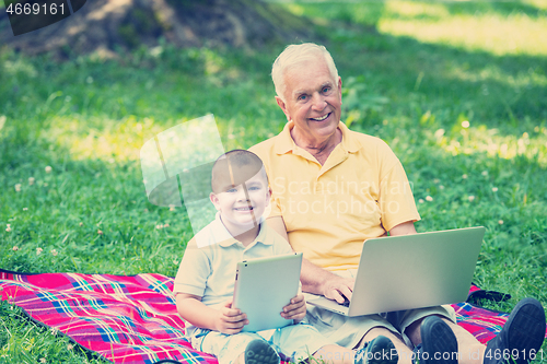 Image of grandfather and child using laptop