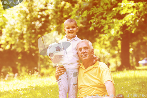 Image of grandfather and child in park using tablet