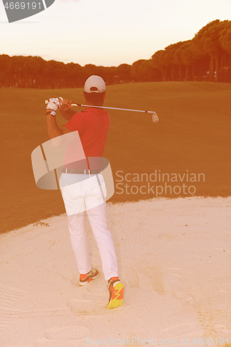 Image of golfer hitting a sand bunker shot on sunset