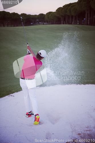 Image of golfer hitting a sand bunker shot on sunset