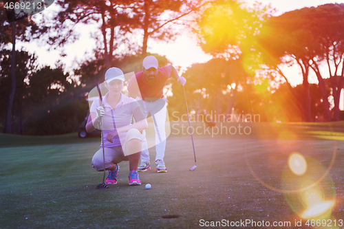 Image of couple on golf course at sunset