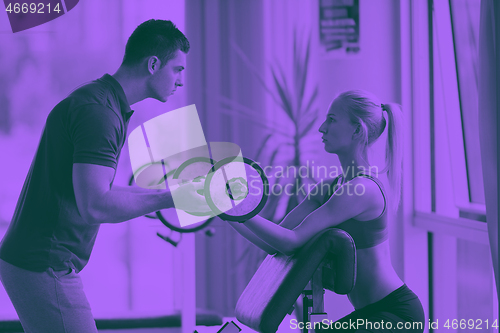 Image of young sporty woman with trainer exercise weights lifting