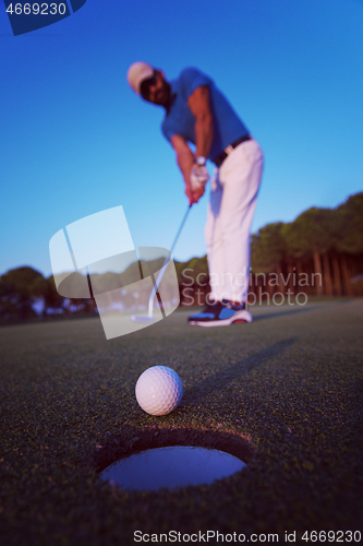 Image of golfer  hitting shot at golf course