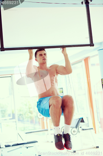 Image of handsome young mand working out in gym