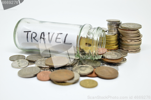 Image of Travel lable in a glass jar with coins spilling out