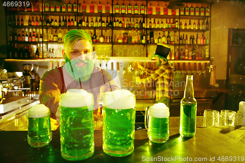 Image of Happy man with glass of beer looking aside in pub