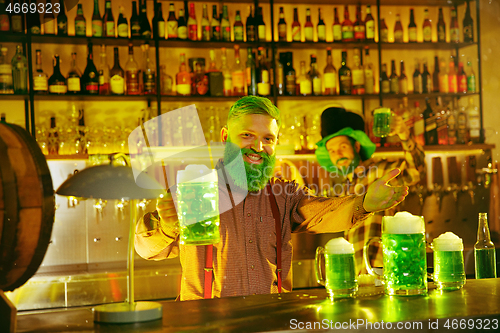 Image of Happy man with glass of beer looking aside in pub