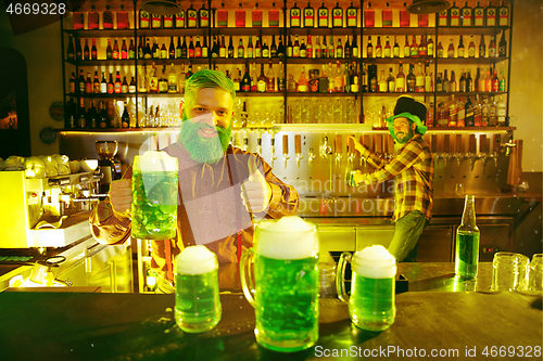 Image of Happy man with glass of beer looking aside in pub