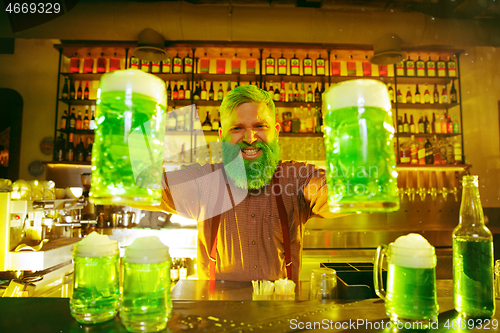 Image of Happy man with glass of beer looking aside in pub