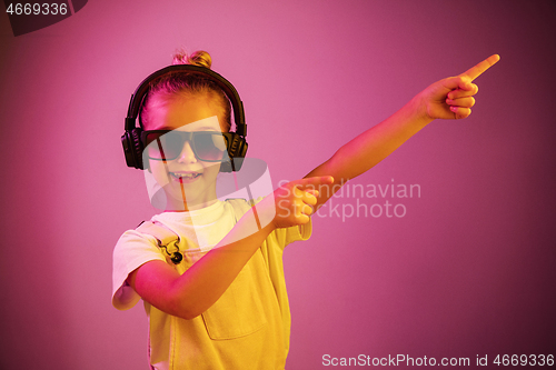 Image of Young girl with headphones enjoying music