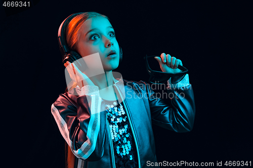 Image of Young girl with headphones enjoying music