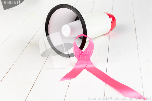 Image of the text world cancer day and a pink ribbon on a table background