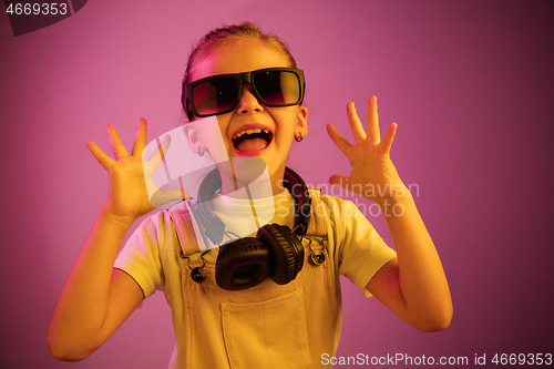 Image of Young girl with headphones enjoying music