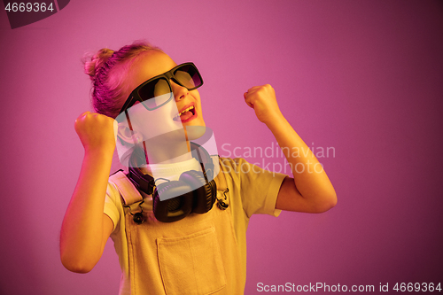 Image of Young girl with headphones enjoying music