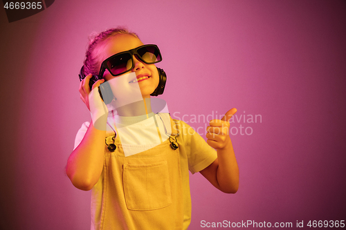 Image of Young girl with headphones enjoying music