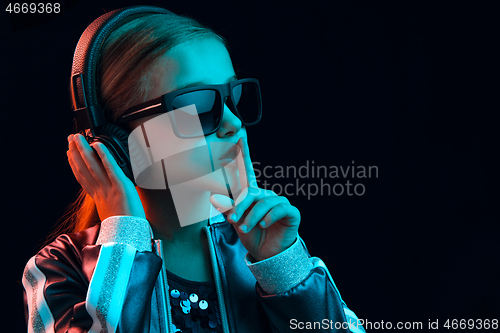 Image of Young girl with headphones enjoying music