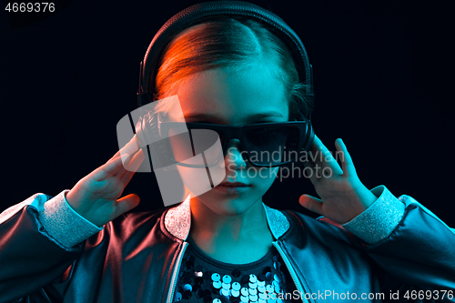 Image of Young girl with headphones enjoying music