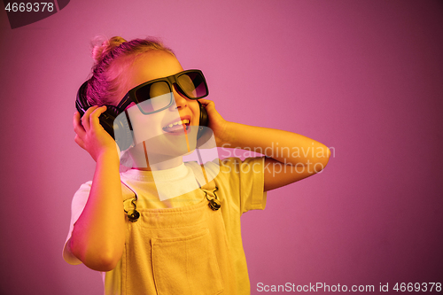 Image of Young girl with headphones enjoying music