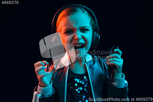 Image of Young girl with headphones enjoying music