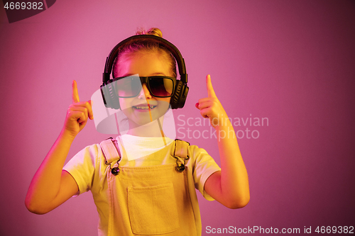 Image of Young girl with headphones enjoying music