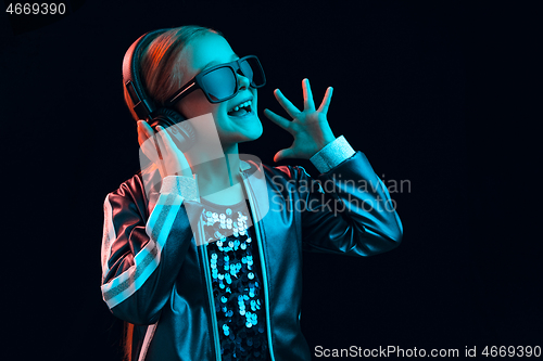 Image of Young girl with headphones enjoying music