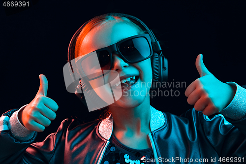 Image of Young girl with headphones enjoying music