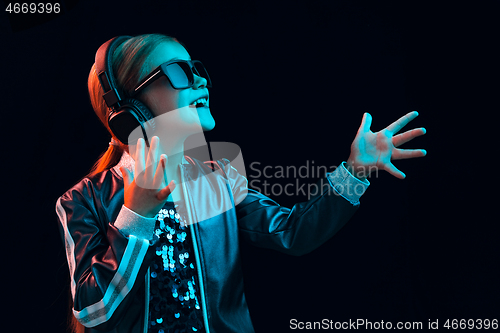 Image of Young girl with headphones enjoying music