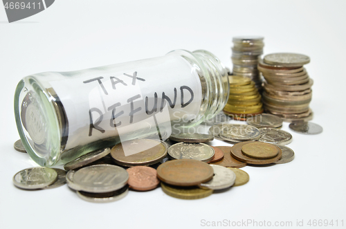 Image of Tax refund lable in a glass jar with coins spilling out