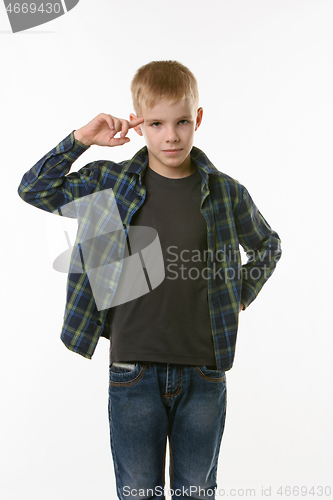 Image of boy put his index finger to the temple on a white background