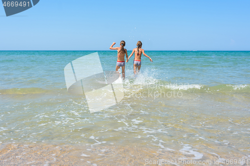 Image of Girls run in the water swimming in shallow water