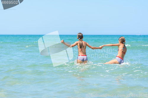 Image of Two girls swim in the sea on a hot day