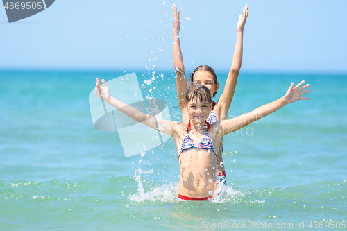 Image of Two girls stood up for each other and joyfully raised their hands up.