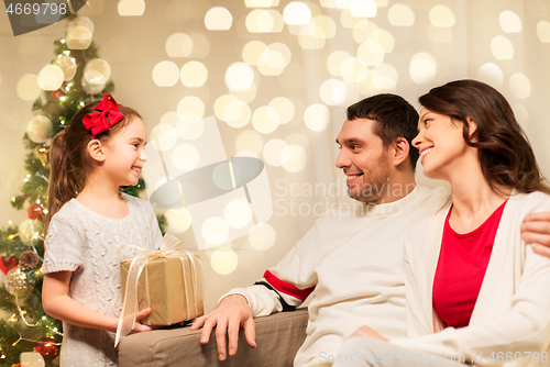 Image of happy family with christmas present at home
