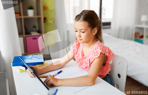 Image of student girl using tablet computer at home