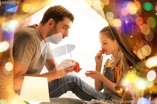 Image of family playing tea party in kids tent at home