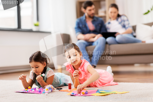 Image of happy sisters doing arts and crafts at home