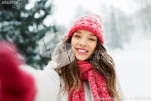 Image of smiling woman taking selfie outdoors in winter