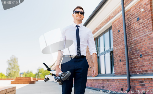 Image of businessman with folding scooter on rooftop