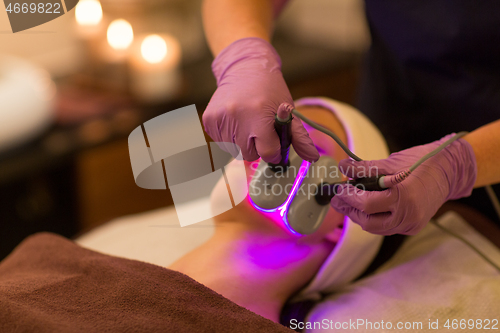 Image of young woman having face microdermabrasion at spa