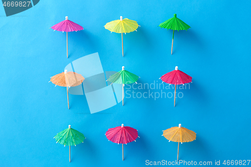 Image of cocktail umbrellas on blue background