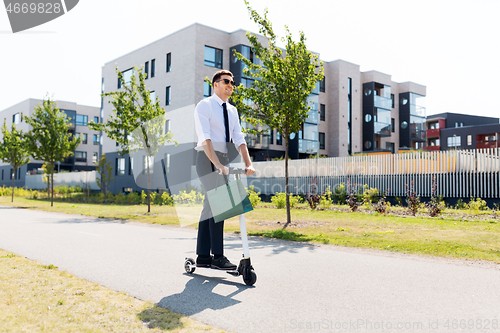 Image of businessman with shopping bag riding scooter